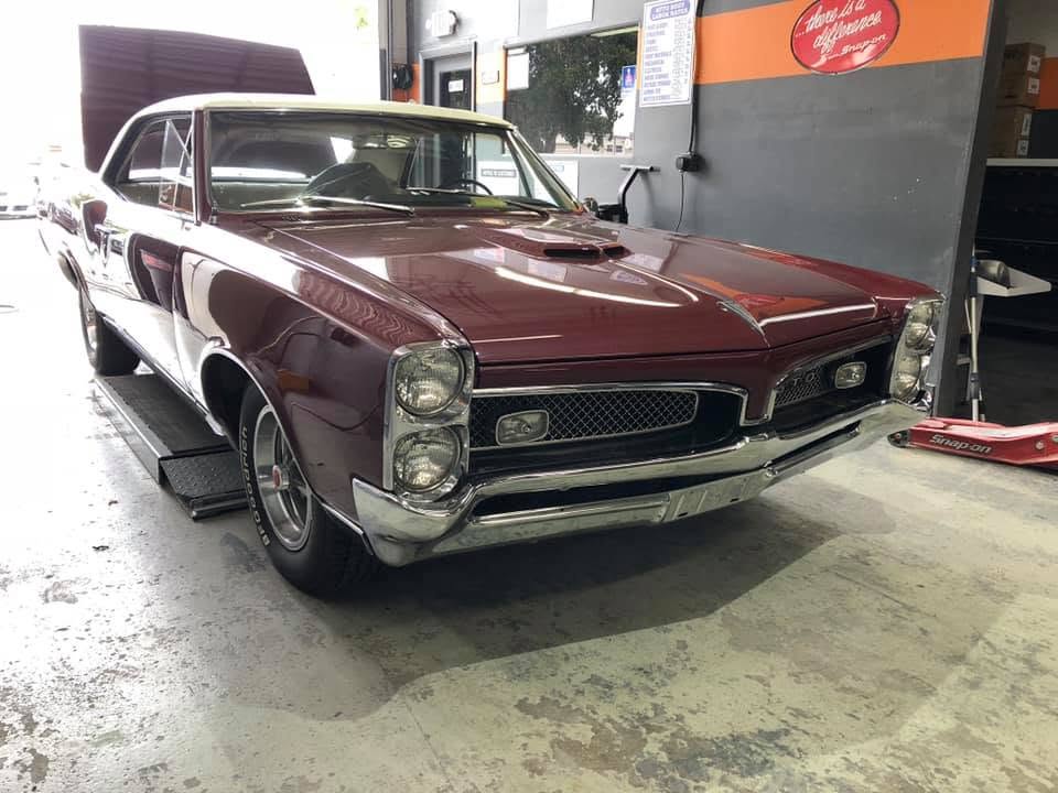 Restored 1967 Pontiac GTO in deep maroon, refinished at Automotive World Collision Center in Miami